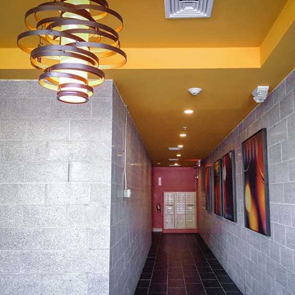 a hallway with a yellow ceiling and a light fixture that looks like a spiral.
